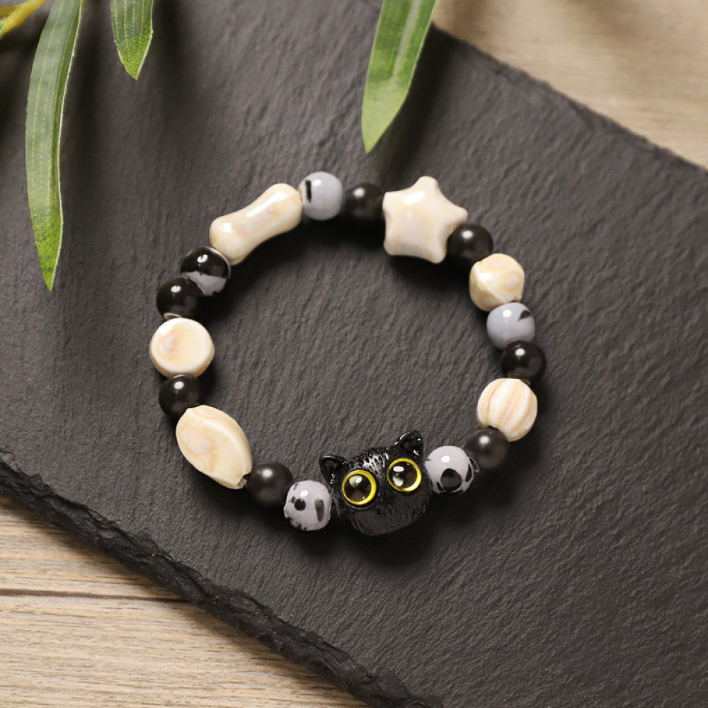 This playful beaded bracelet features a charming lucky cat ceramic bead at its center, paired with whimsical ceramic charms like stars, bones, and flowers, interspersed with small brown beads. Crafted from ceramic, it brings a cute, kawaii vibe to everyday outfits 06