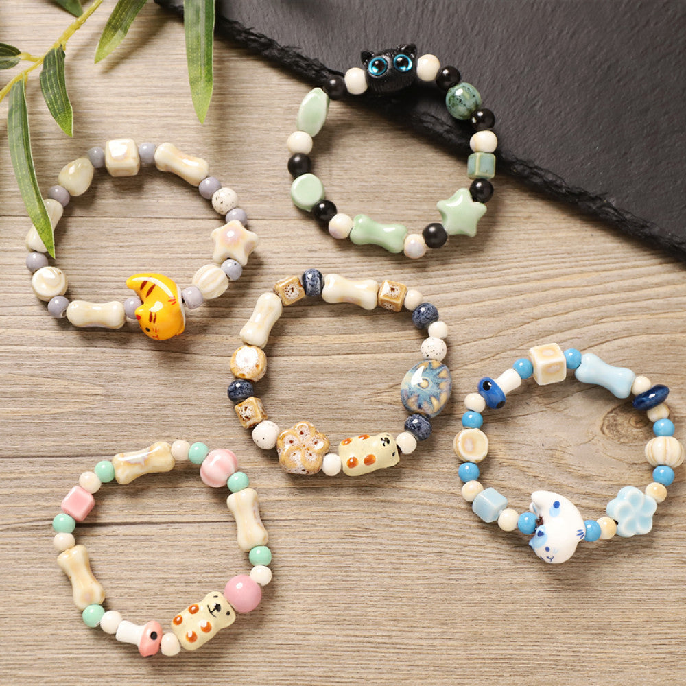 This playful beaded bracelet features a charming lucky cat ceramic bead at its center, paired with whimsical ceramic charms like stars, bones, and flowers, interspersed with small brown beads. Crafted from ceramic, it brings a cute, kawaii vibe to everyday outfits 07