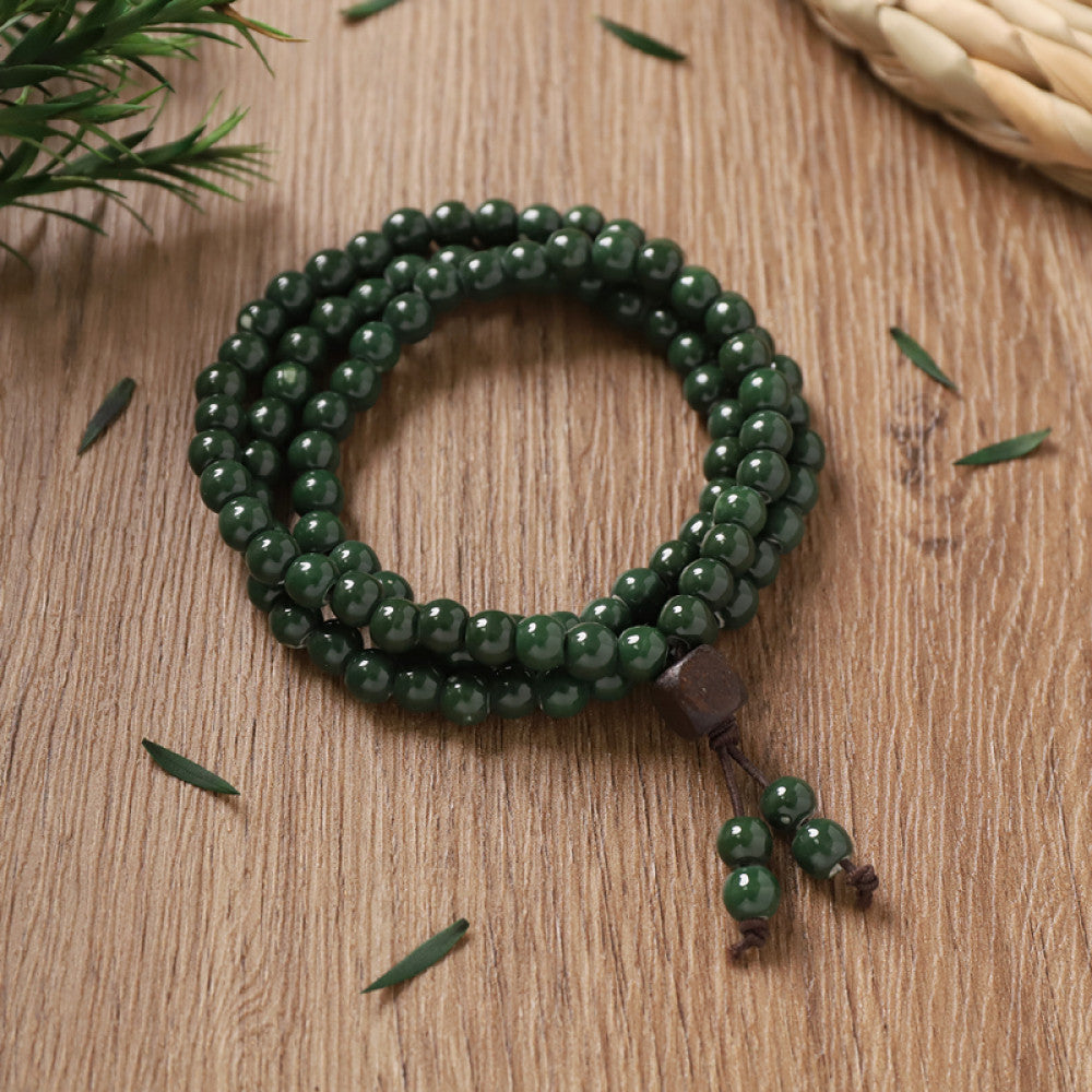 Deep green ceramic beads, forest-like calm, with green tassel pendants.