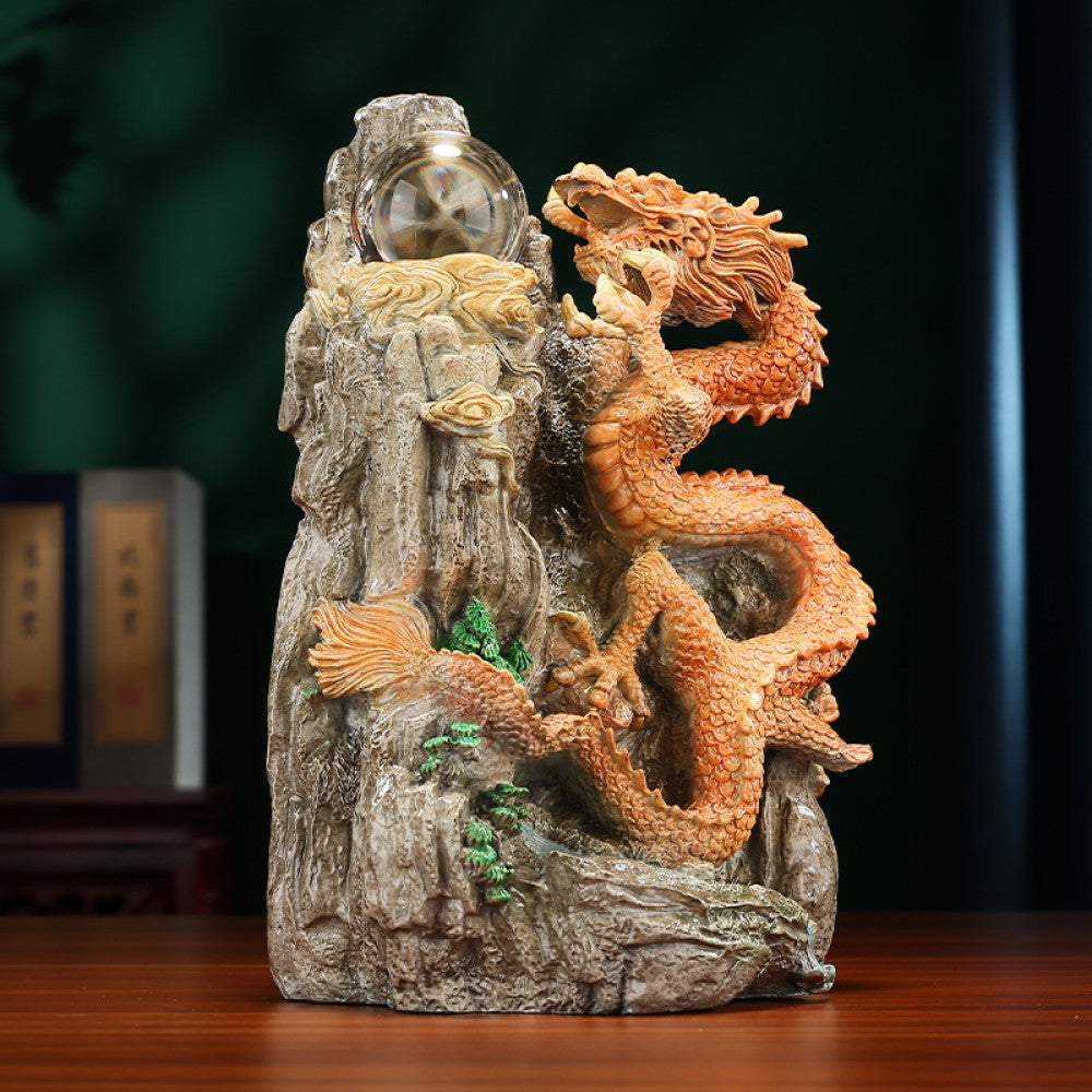 Intricate orange dragon statue with a crystal ball, a Feng Shui symbol of good fortune and strength, displayed as unique home decor on a wooden table against a dark green background