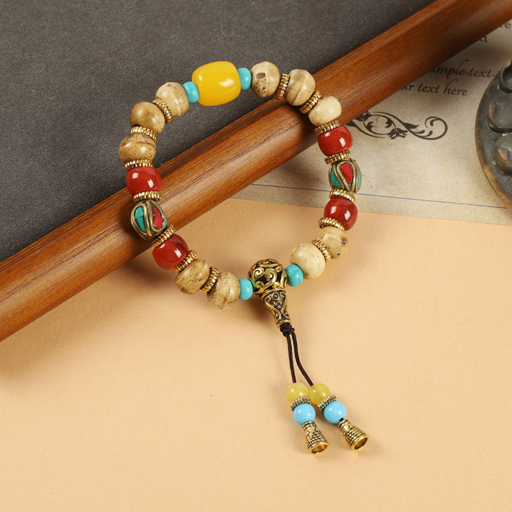 This ethnic-style bracelet features a mix of white, yellow, and red ceramic beads, accented with turquoise details and an adjustable tassel closure for a unique, cultural-inspired loo 1