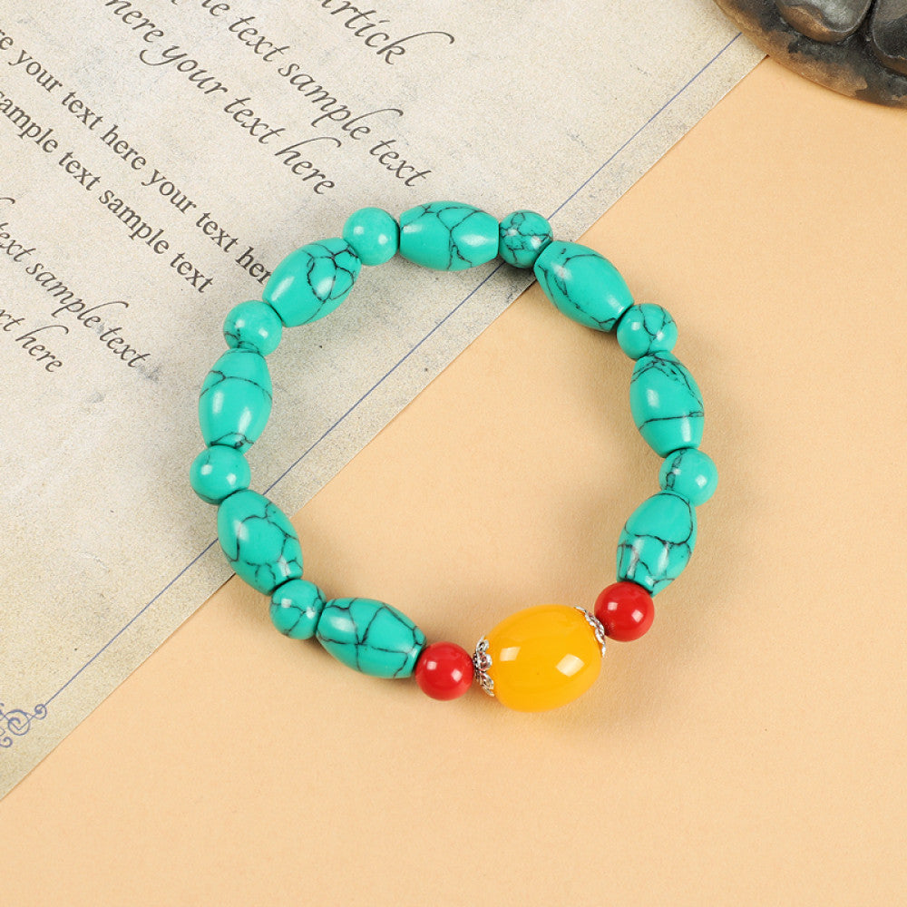 This ethnic-style bracelet features a mix of white, yellow, and red ceramic beads, accented with turquoise details and an adjustable tassel closure for a unique, cultural-inspired look 2
