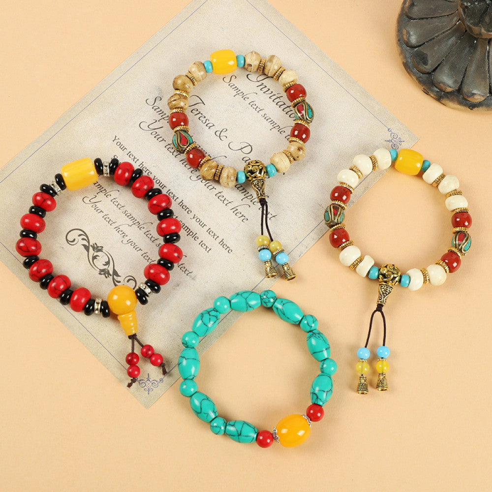 This ethnic-style bracelet features a mix of white, yellow, and red ceramic beads, accented with turquoise details and an adjustable tassel closure for a unique, cultural-inspired look 6