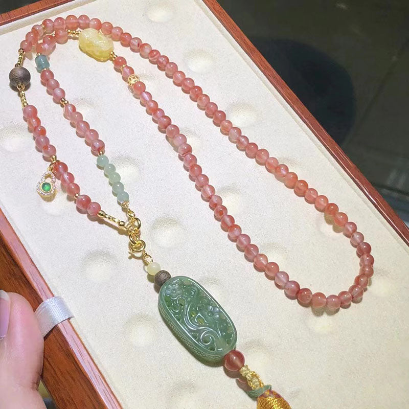 A hand - presented necklace composed of pink quartz beads, a intricately carved green jade piece, and various accent beads. This piece is a great choice for fashion - forward individuals seeking unique jewelry