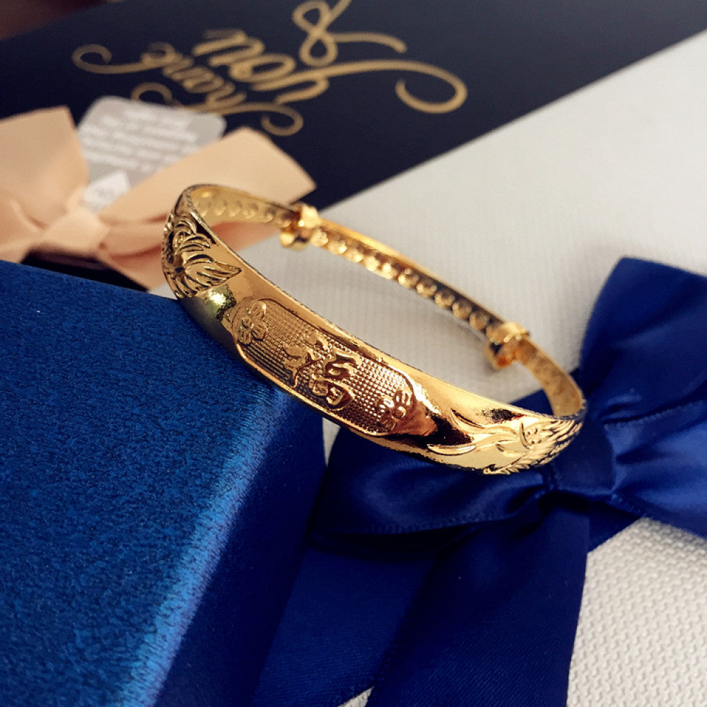 Fashion gold-tone adjustable bangle with sleek design, displayed on blue gift box with ribbon, ideal for luxury and contemporary fashion enthusiasts 0