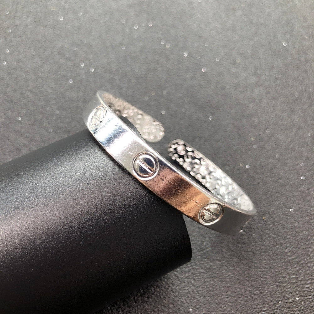 Fashion luxury love-inspired silver cuff bangle, styled on a sleek surface, ideal for elegant and trendy fashion enthusiasts in the US