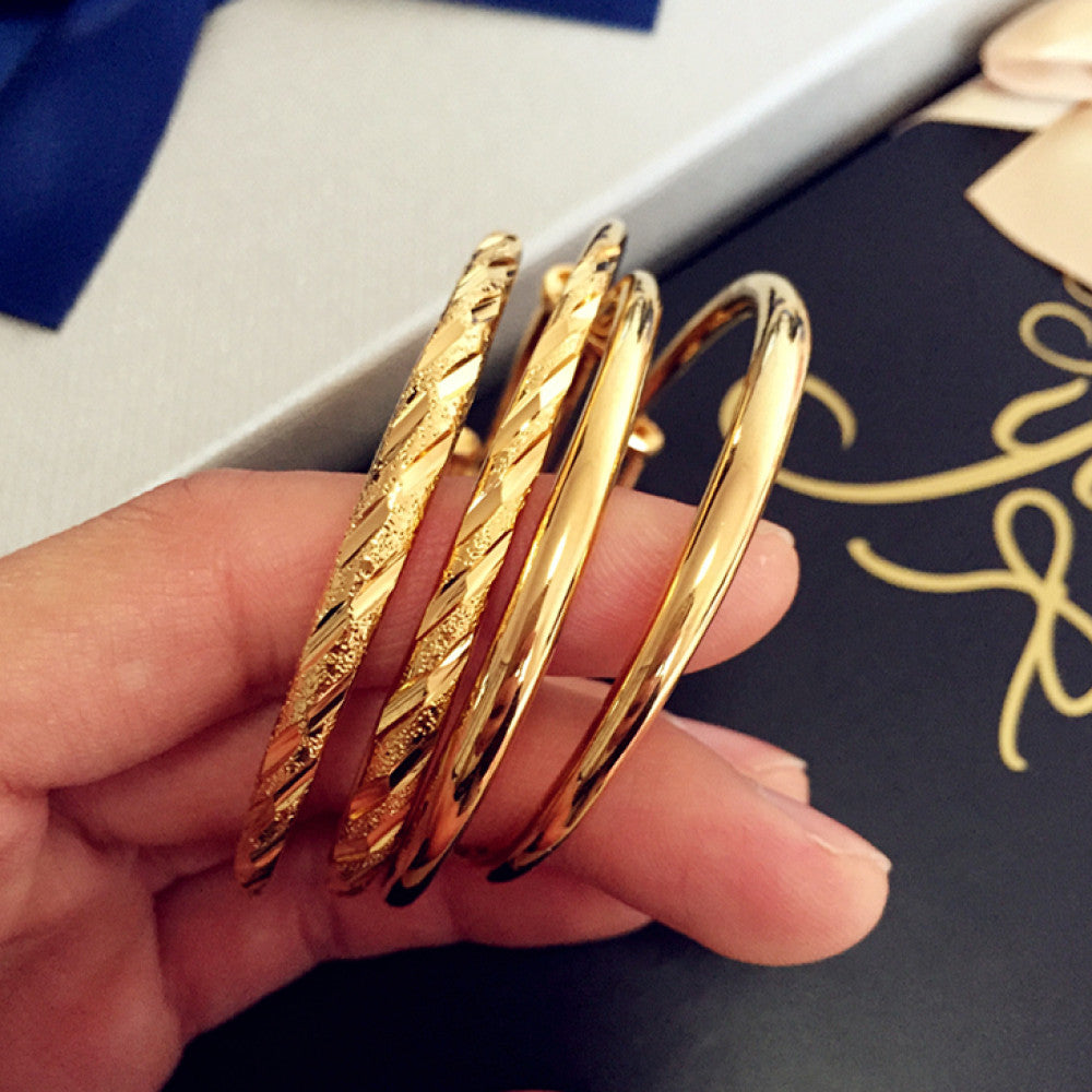 Fashion luxury gold bangle set with mixed textures, styled in hand for display, ideal for elegant and trendy fashion enthusiasts in the US