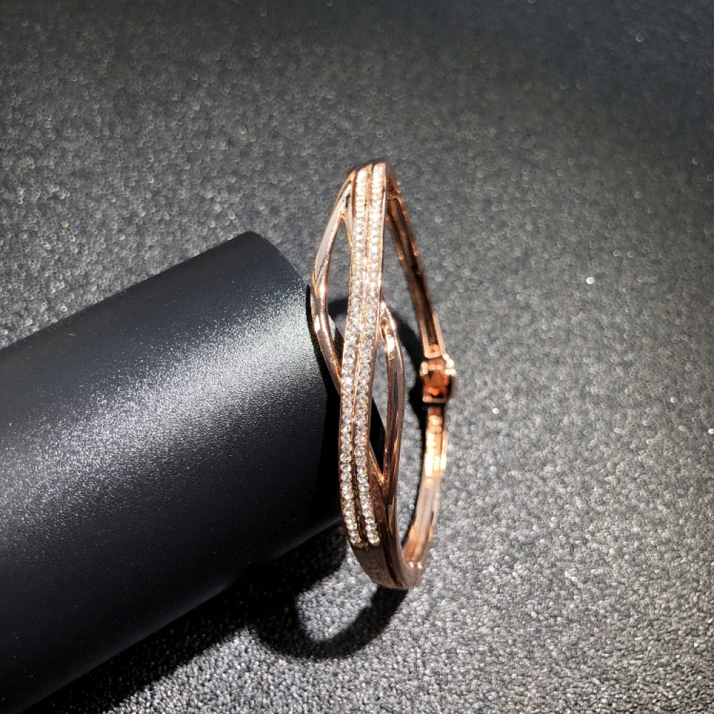 Fashion luxury rose gold bangle with diamond-encrusted signature logo, displayed on black surface, ideal for luxury fashion and statement jewelry enthusiasts 03