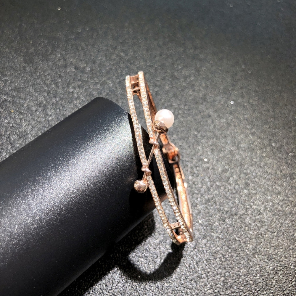 Fashion luxury rose gold bangle with diamond-encrusted signature logo, displayed on black surface, ideal for luxury fashion and statement jewelry enthusiasts 7