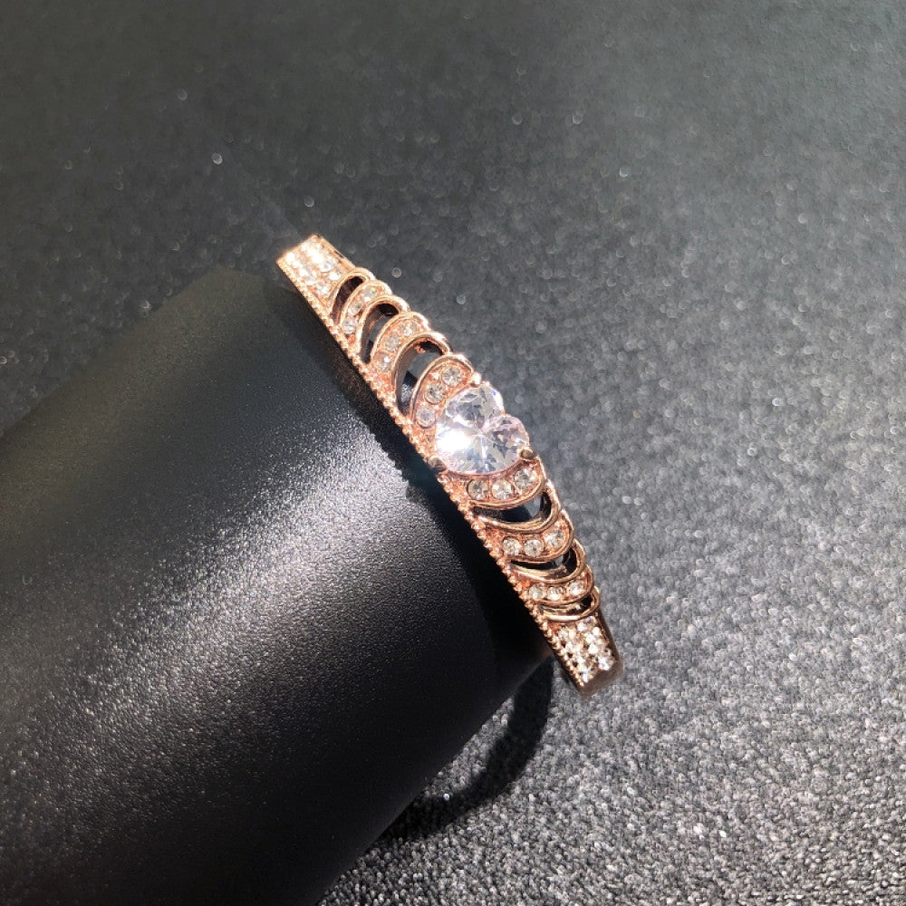 Fashion luxury rose gold bangle with heart-shaped diamond and intricate designs, displayed on black surface, ideal for luxury fashion and special occasion enthusiasts
