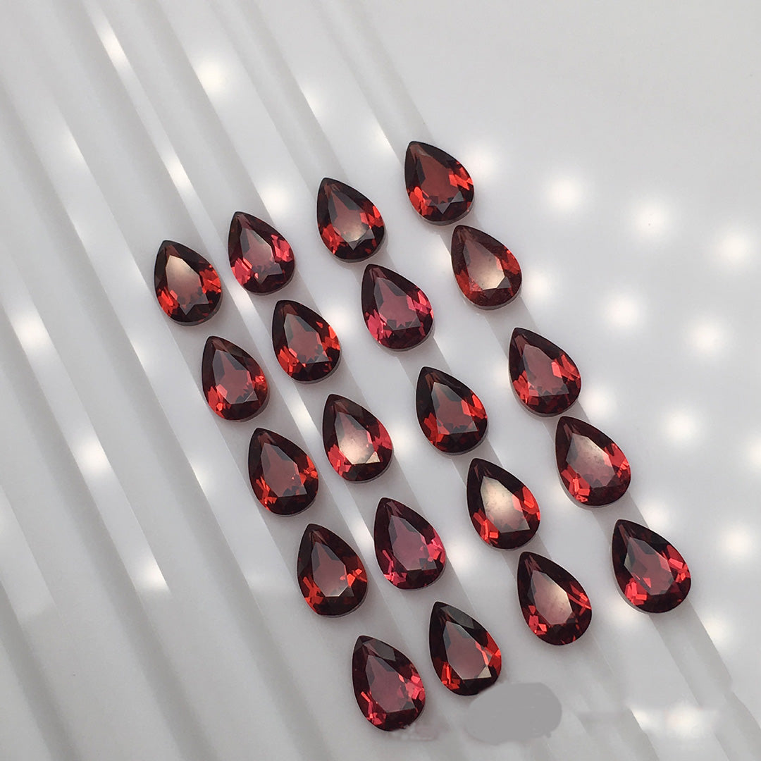 Teardrop-shaped garnet rough stones, wine-red crystals, 24 pieces on display, showcasing the charm of gemstones.
