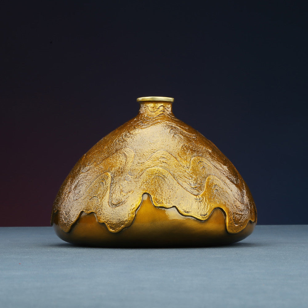 Golden art vase with brass branch and bird decoration against dark gradient background 01