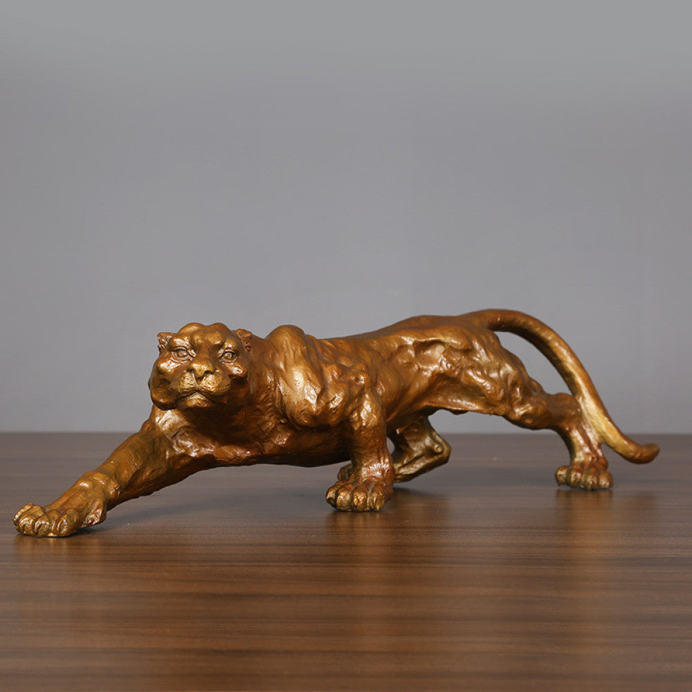 Golden panther statue with a dynamic running pose, featuring a metallic finish, ideal as an Art Deco home decor piece symbolizing strength and courage, displayed on a wooden surface against a gray background 01