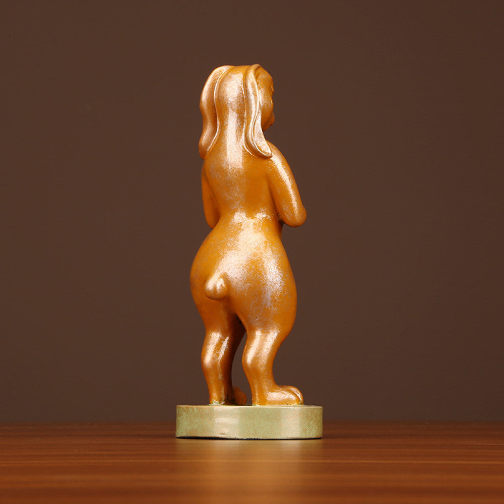 Golden rabbit statue in a standing pose holding a red accent, a symbol of good luck for home decor, placed on a greenish base against a brown background 02