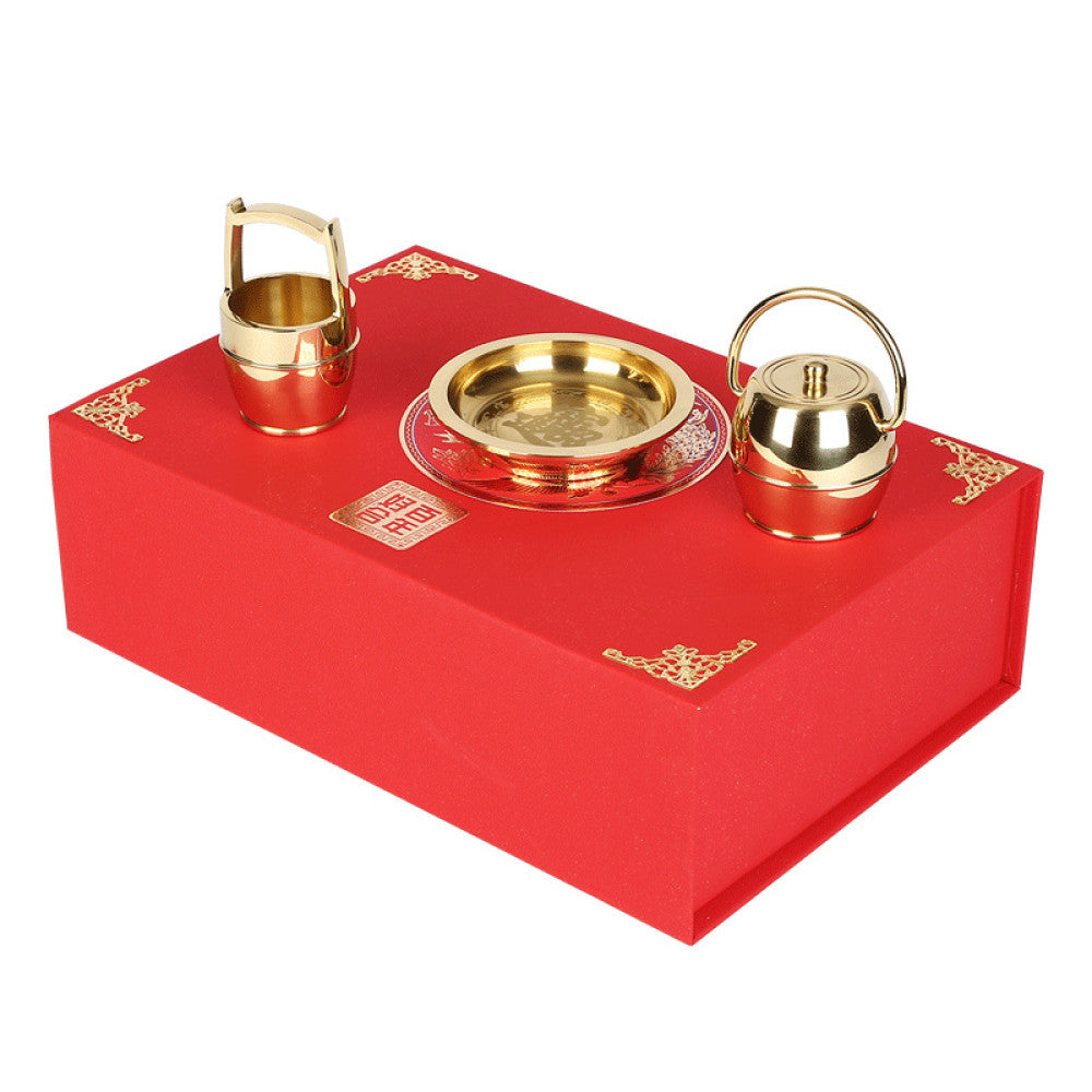Golden Chinese wedding tea ceremony utensils placed on red decorative gift box
