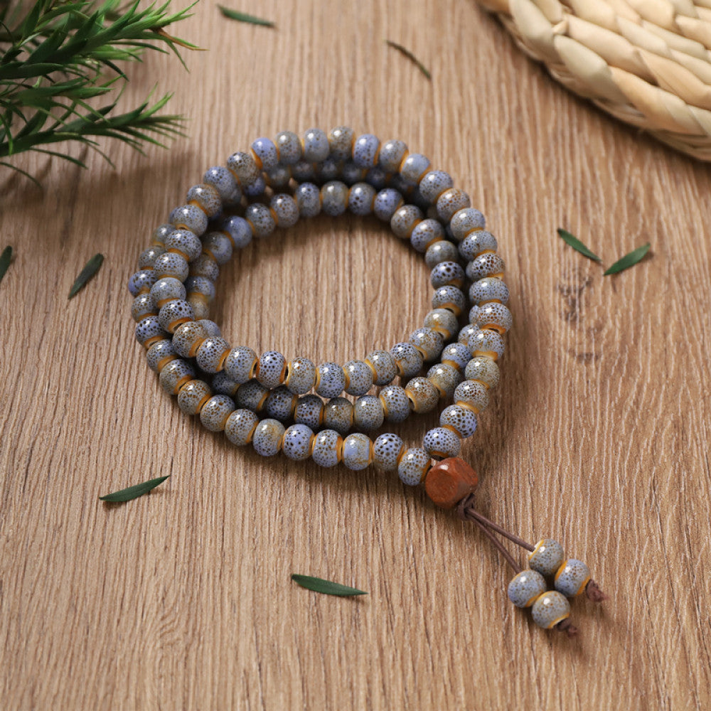 Grey-blue marbled beads, cool and mysterious, with amber tassel detail.