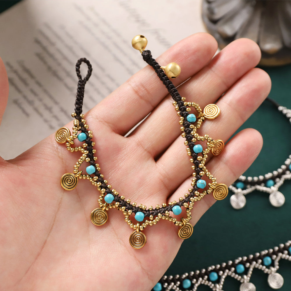 Close-up of the golden anklet in hand, highlighting craftsmanship and texture.