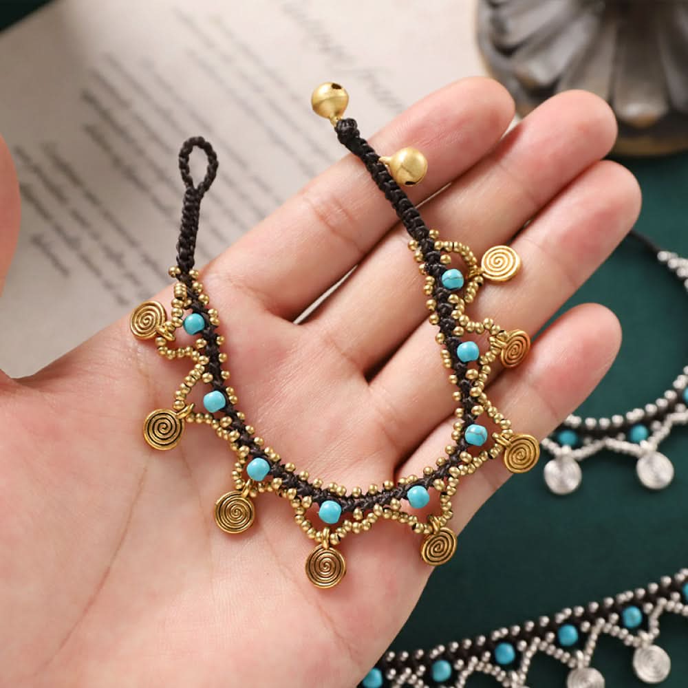 Close-up of the golden anklet in hand, highlighting craftsmanship and texture.