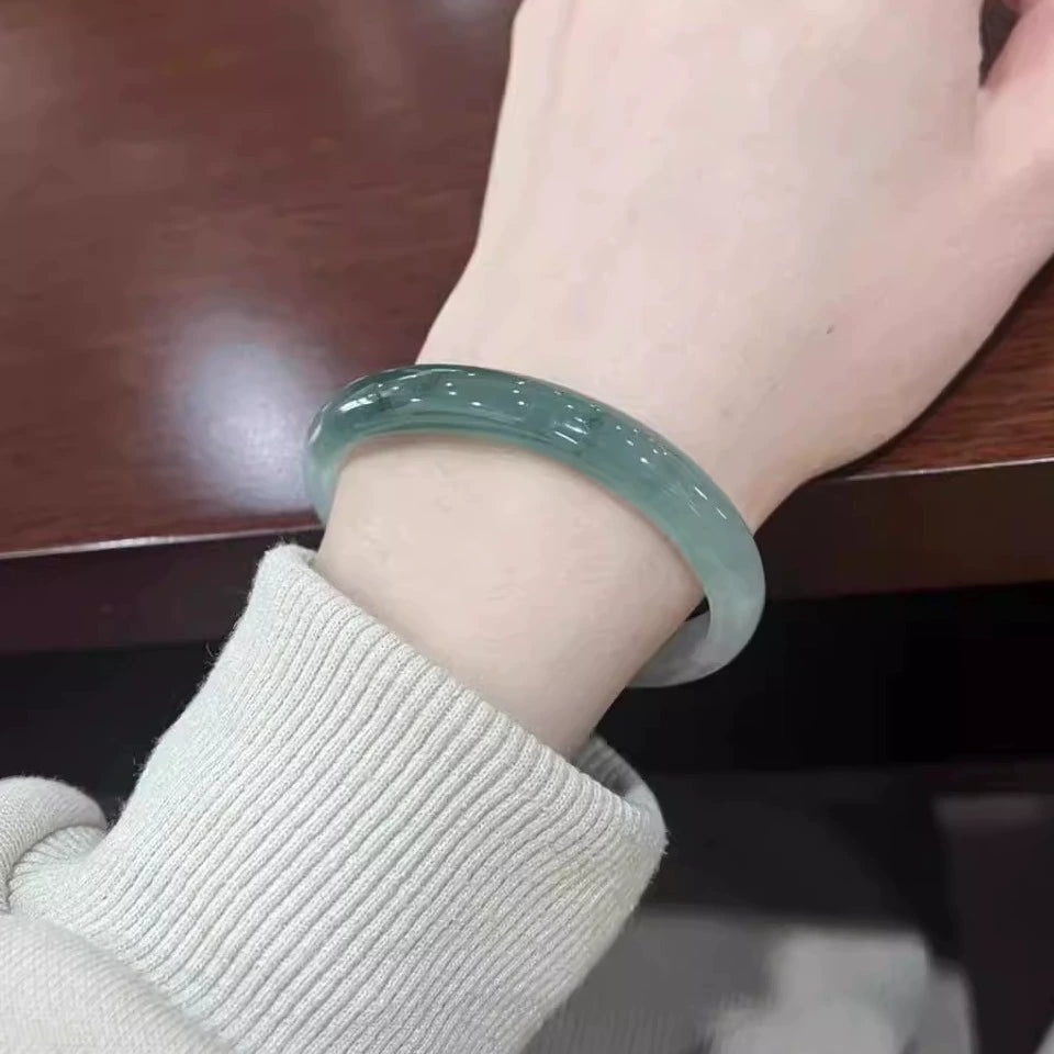 Woman wearing icy blue water natural jade bangle, translucent Chinese jade bracelet 01