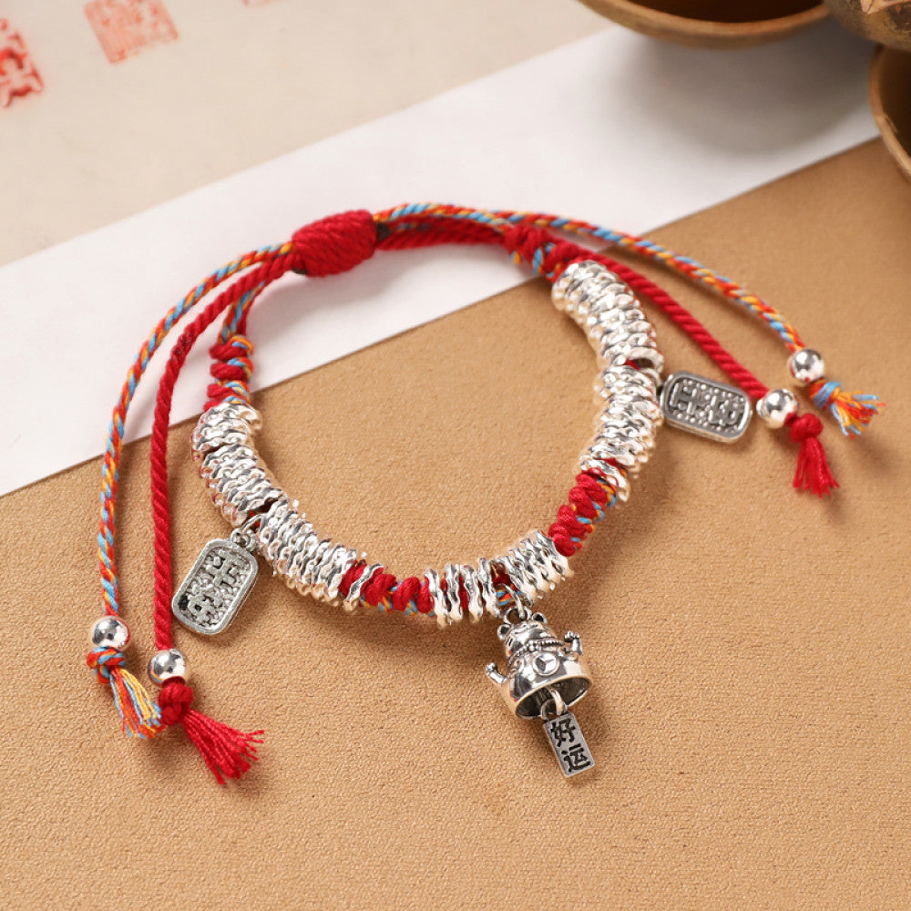 Red braid with a lock-shaped silver charm, symbolizing safety and good fortune.