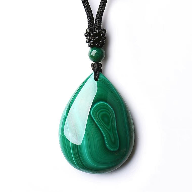 A necklace with a teardrop - shaped malachite pendant and a malachite bead, attached to a black braided cord.
