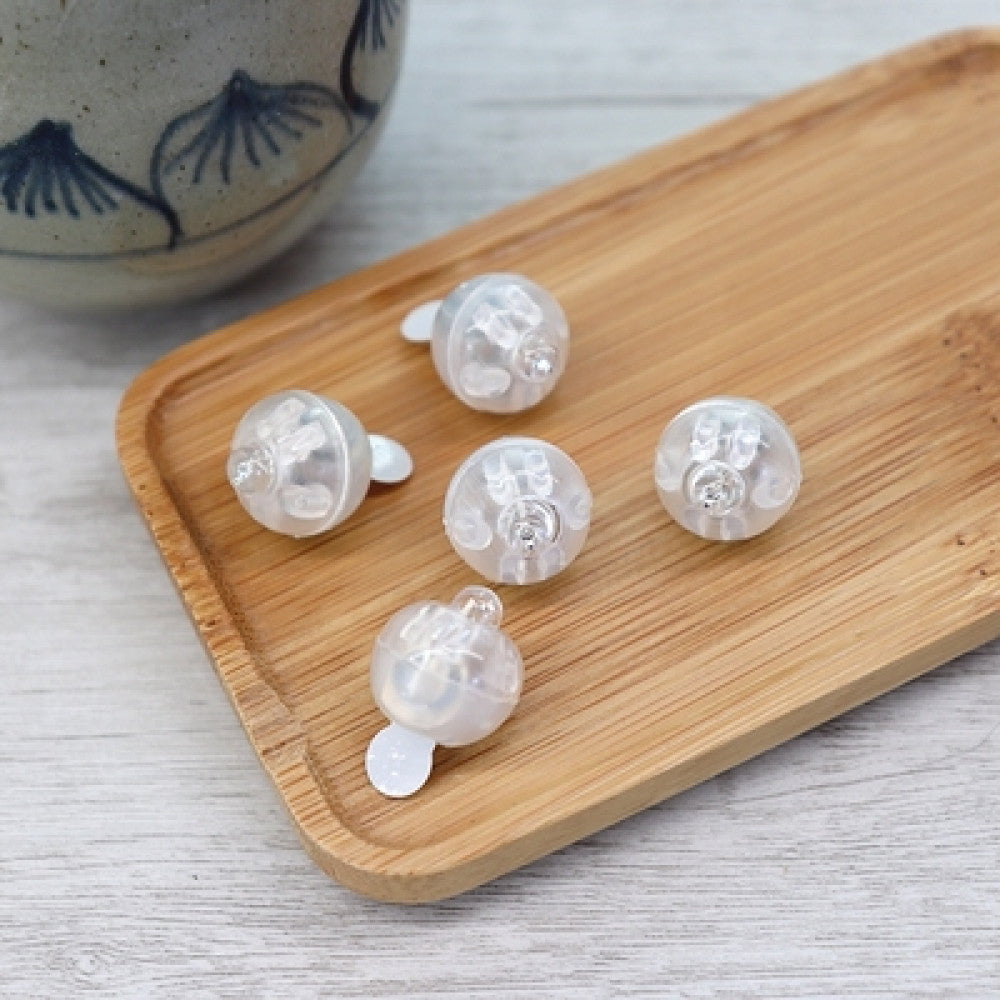 Minimalist clear ear clips arranged on a wooden tray, perfect for DIY jewelry making and non-pierced ear fashion