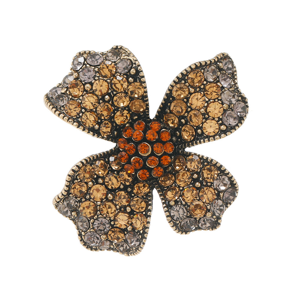This eye-catching brooch features a striking four-petal floral design, crafted on an antiqued metal base and lavishly adorned with a dazzling array of crystals. Each petal shimmers with a gradient of clear and golden crystals, while a vibrant cluster of orange crystals anchors the center, creating a bold, layered effect. Perfect for adding a touch of vintage glamour to blazers, scarves, or evening wear, this piece blends intricate craftsmanship with timeless, eye-catching charm 03