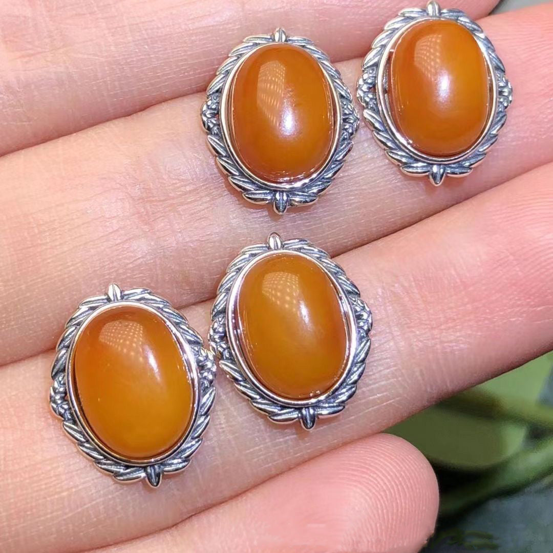 Retro-style silver-inlaid old amber earrings, oval amber shape, exquisite silver decoration surrounding