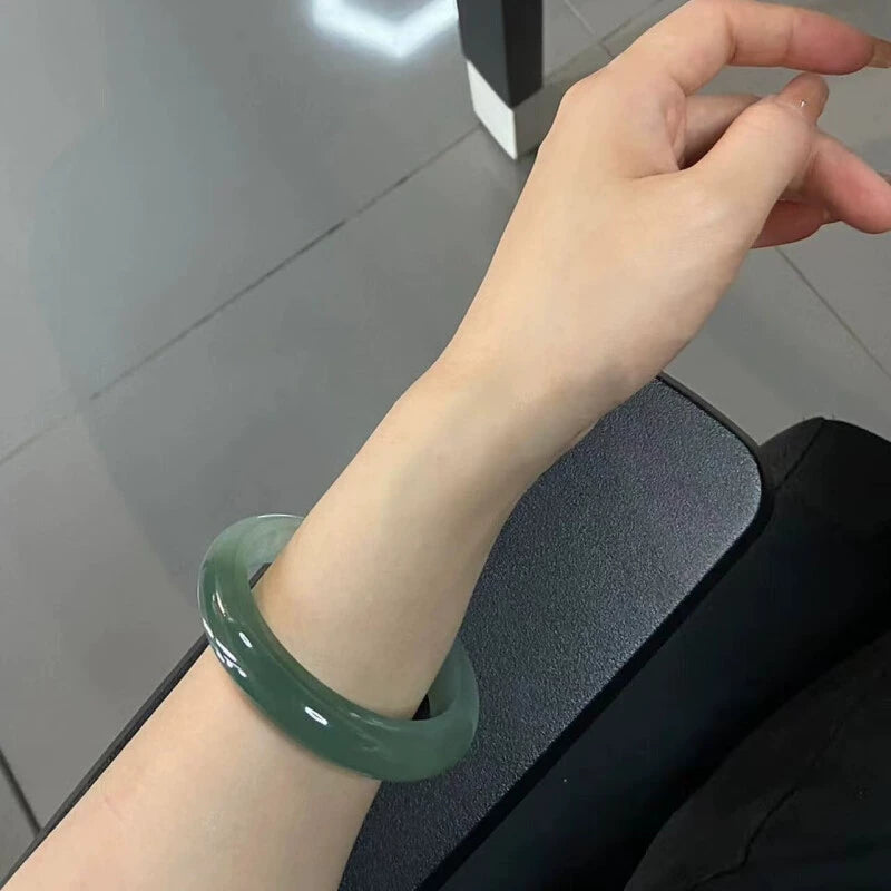 Woman wearing natural dark green jade bangle, luxury Chinese jade jewelry 01