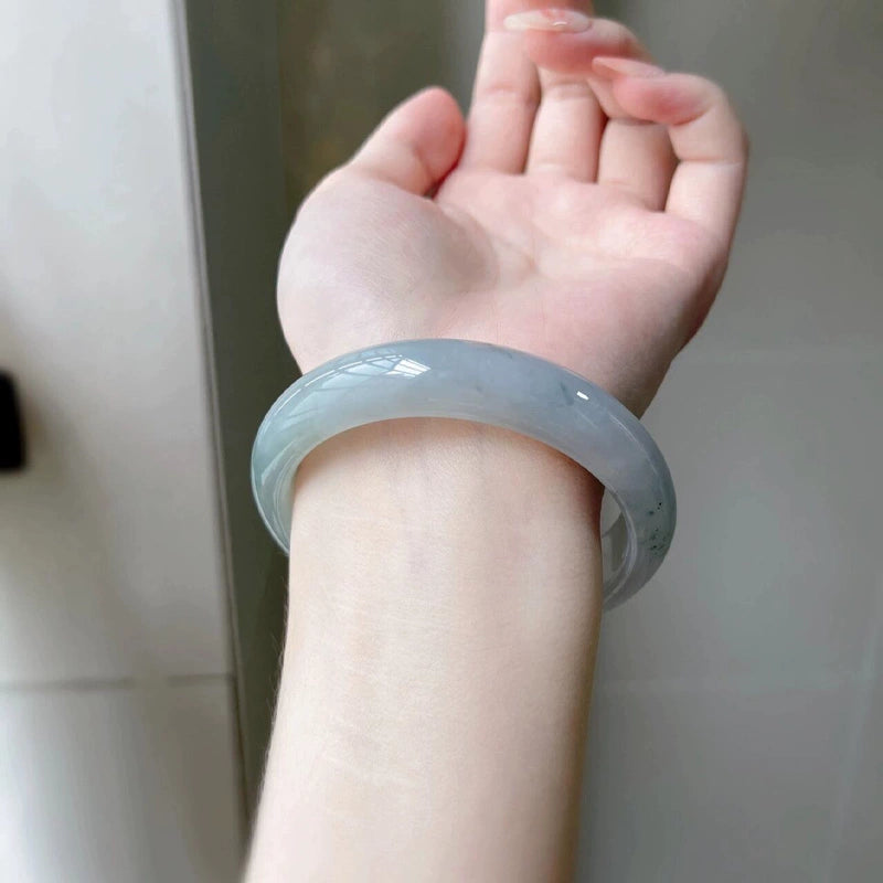 Hand holding natural icy lavender green jade bangle 01