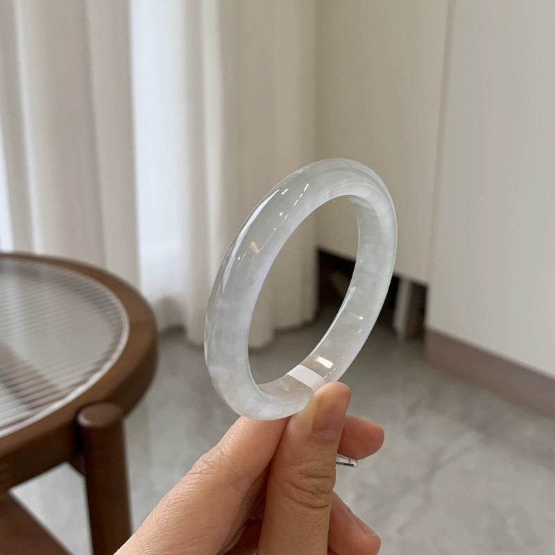 Wrist wearing natural icy light green jadeite bangle and gold bracelet in urban setting 01