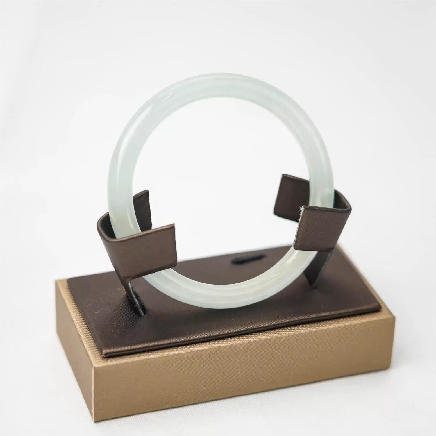 Light green icy translucent jade bangle on display stand