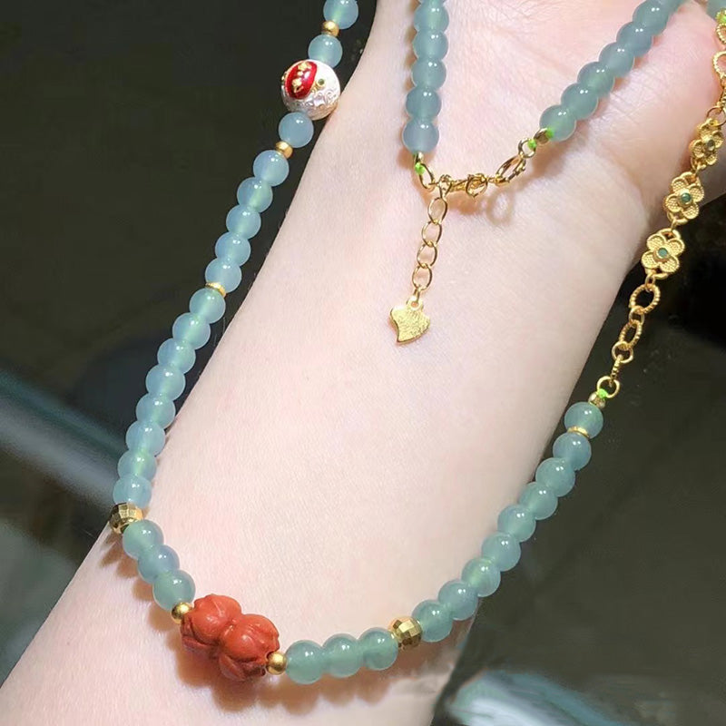 Handmade green jade beaded necklace with natural cinnabar flower pendant, gold chain extender, and lucky charm, ideal for gifts or personal wear