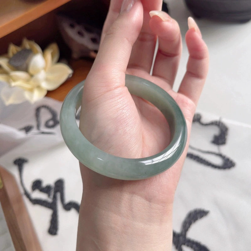 Hand holding natural oil green jade bangle, Chinese jade jewelry 01