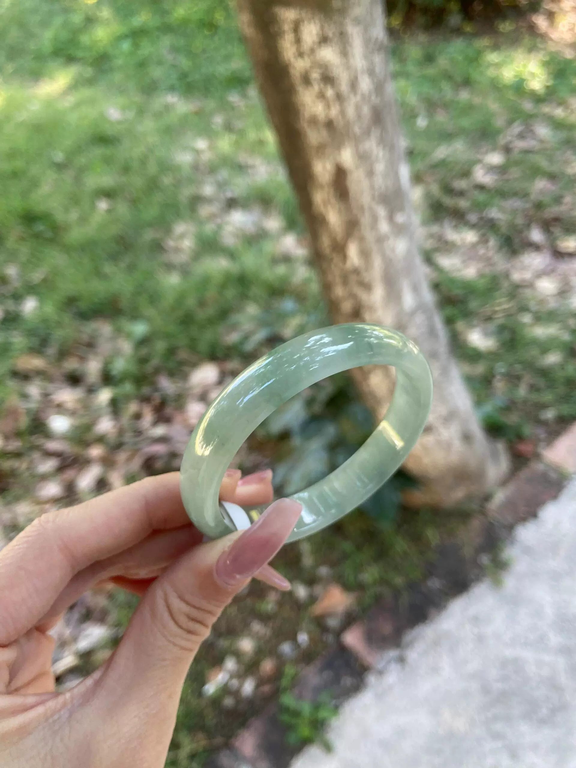Women's Natural Translucent Green Jade Bangle Bracelet - Outdoor Close-up 01