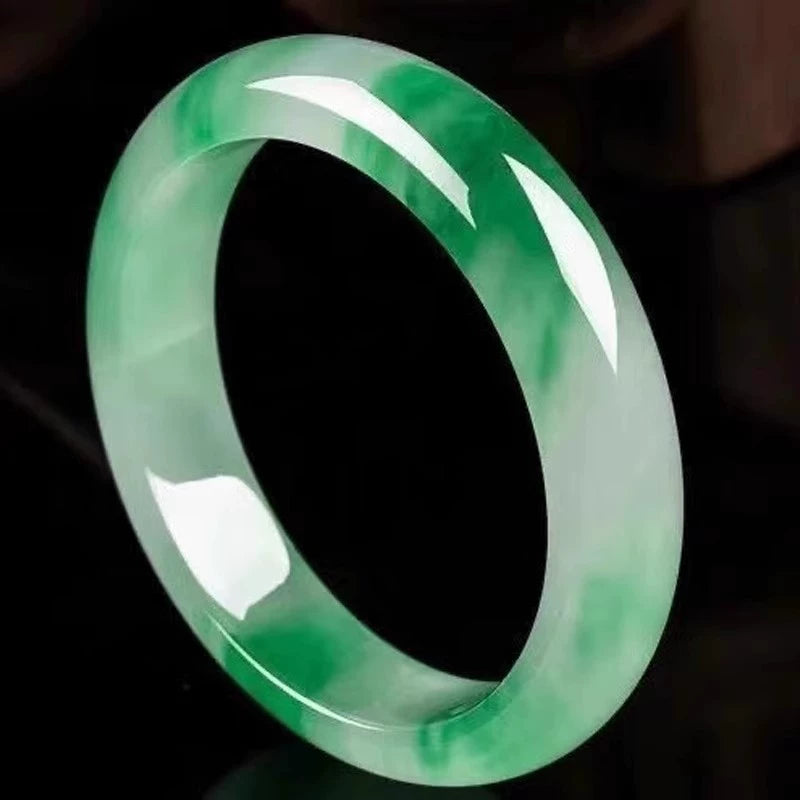 Natural vivid green gradient jadeite bangle against black background with glossy finish 02