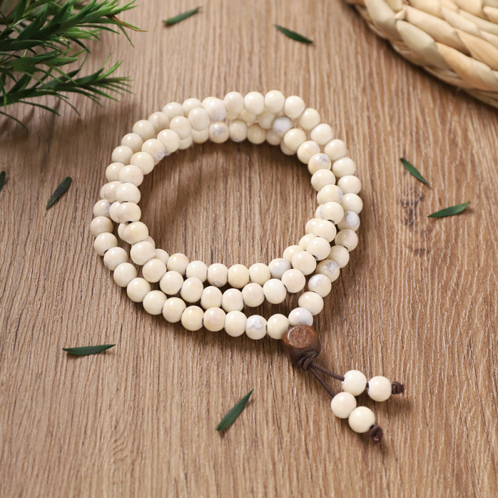 Cream-colored beads, clean and minimalist, with white tassel accents.
