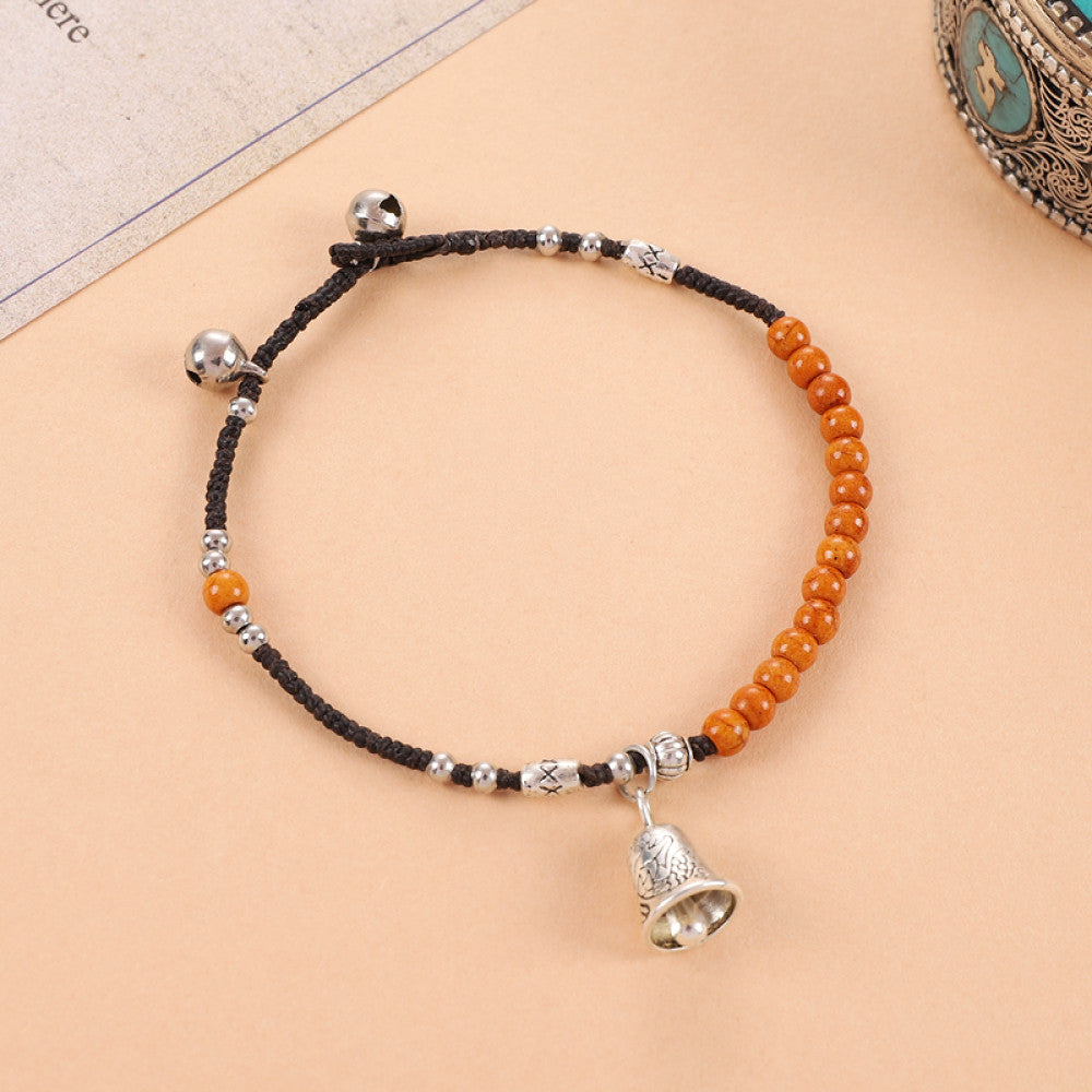 Orange beads with small silver bell, jingly and cute.