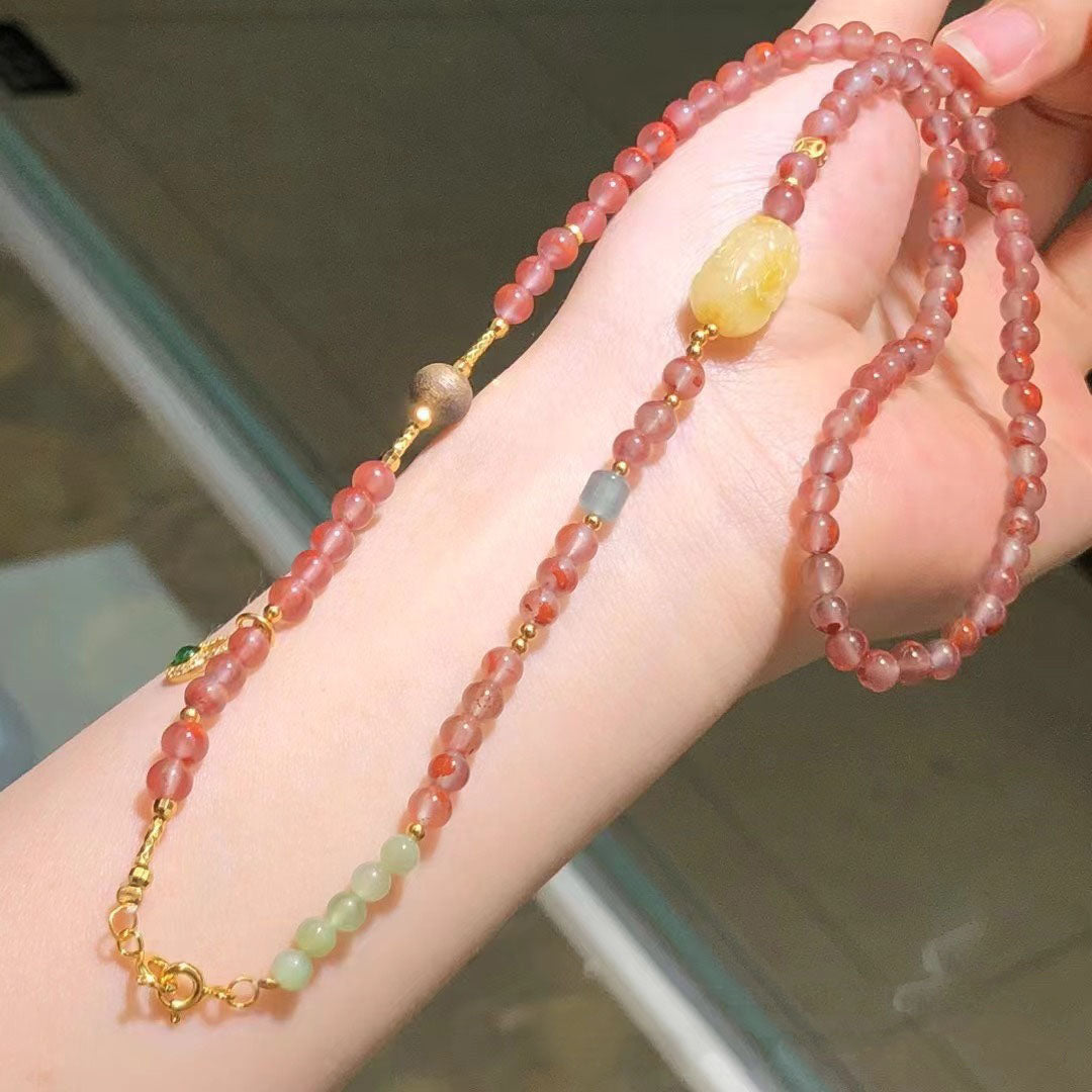 A hand - held necklace featuring a gold chain, with large old - style beeswax beads and small South Red Agate beads as accents, suitable for adding an elegant touch to any outfit