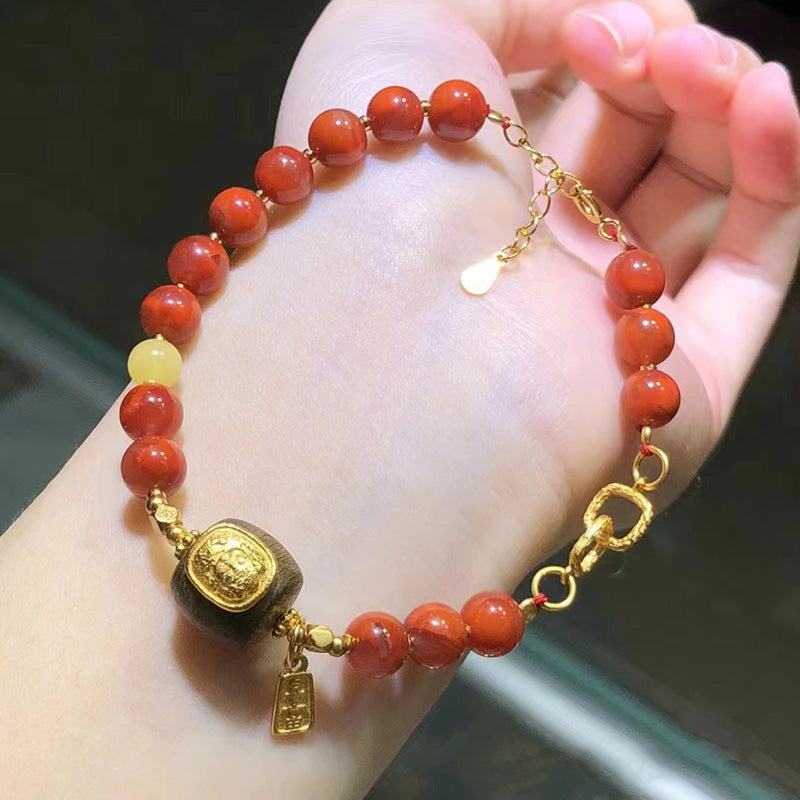 Red agate bracelet, gold - accented charm bracelet