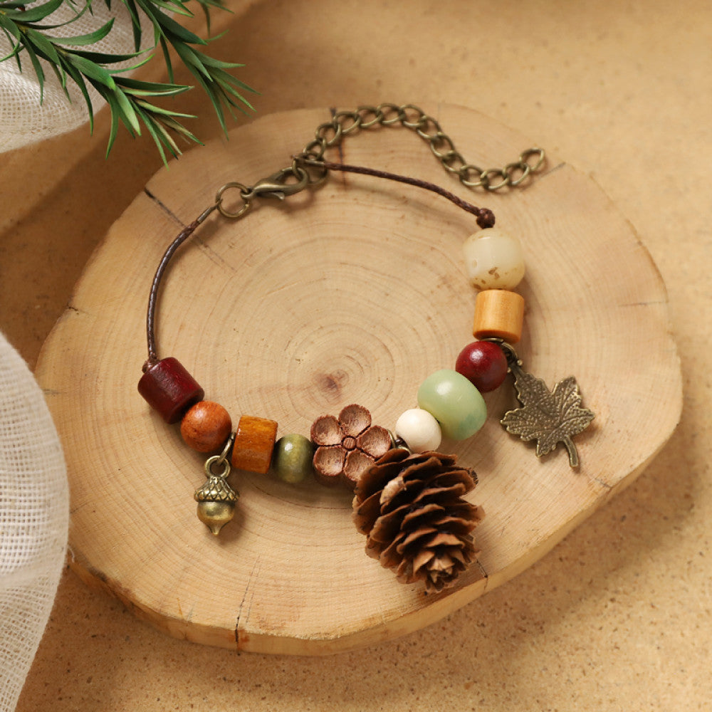 Red beads with a pine cone, warm and autumnal feel.