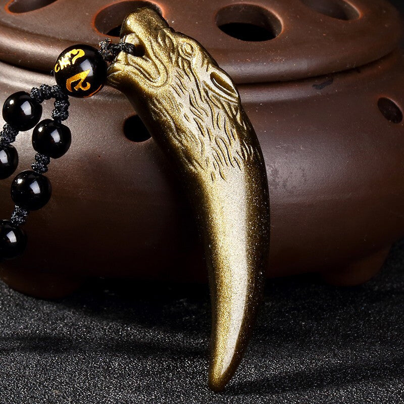 Red cinnabar pendant intricately carved into the shape of a wolf tooth, attached to a red rope, set against a dark - toned background. 01