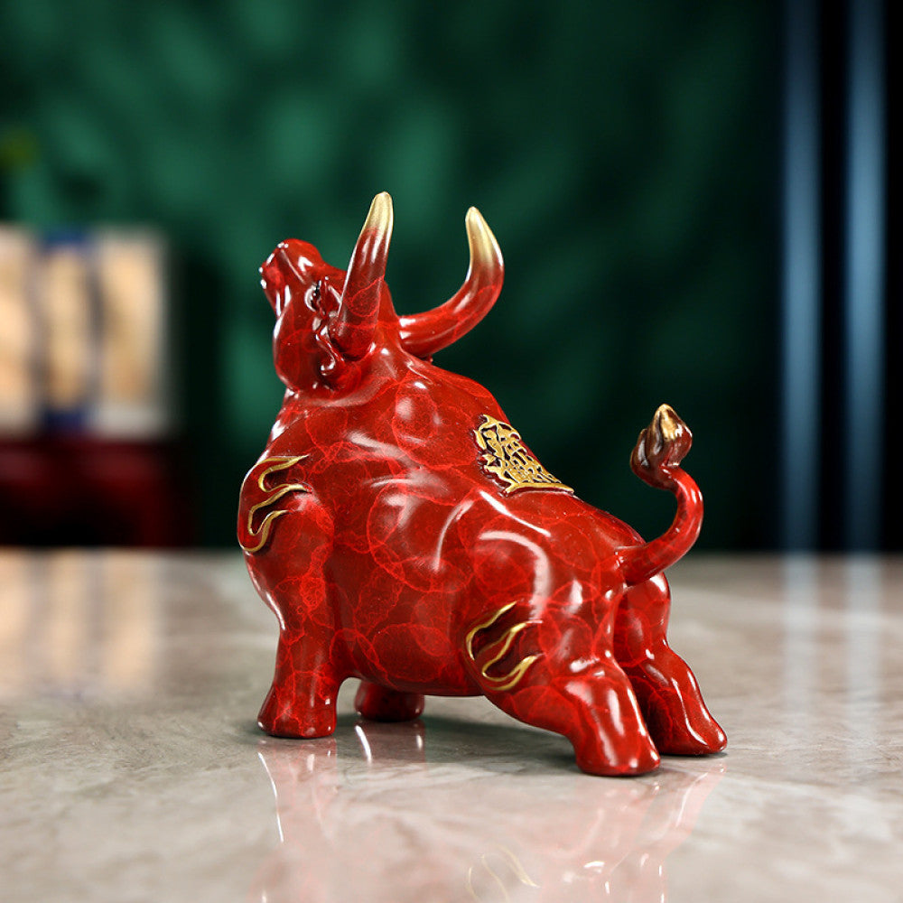 Red bull statue with golden accents and intricate details, a Feng Shui symbol of strength and good fortune, displayed on a polished surface against a green background 01