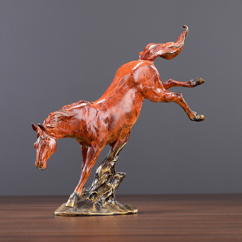 Red galloping horse statue with intricate details, a Feng Shui symbol of success and strength, displayed as elegant home decor on a wooden table against a gray background