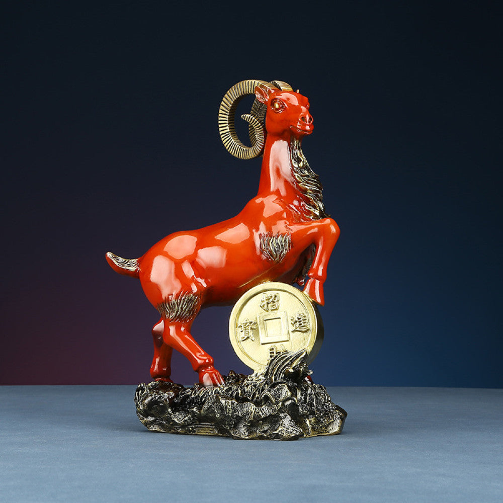 Red goat statue with golden coin detail, a Feng Shui symbol of wealth and good fortune, displayed as elegant home decor against a dark background