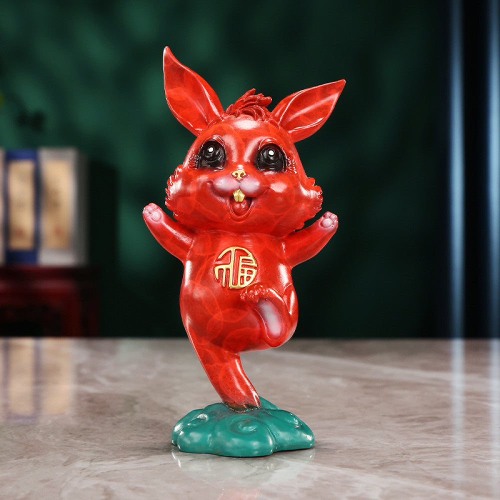 Cute red rabbit statue with golden fortune symbol, a Feng Shui symbol of good fortune, displayed as charming home decor on a marble table against a dark background