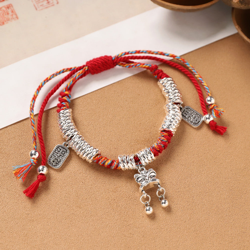 Braided red cord with silver pendants and tassels, traditional Chinese charm.
