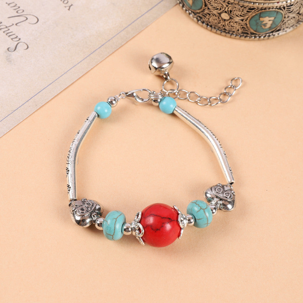 Red and turquoise beads clash, vibrant bohemian look.