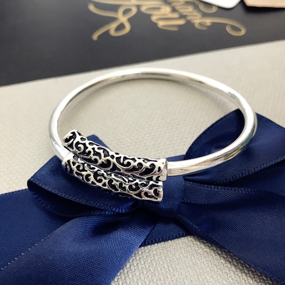 Rose gold plated bangle with engraved detail, displayed on textured surface, ideal for luxury fashion and minimalist jewelry enthusiasts 03