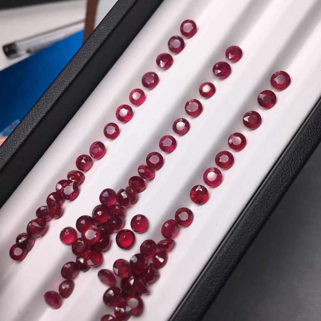 Round rubies on a white stand, some arranged in order, some scattered, jewelry raw material display